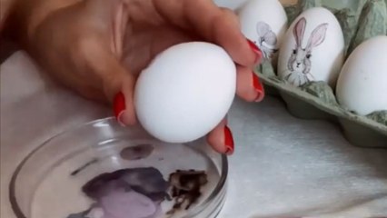 Artist hand paints an egg with beautiful floral pattern for Easter