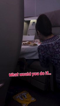 Assistente de bordo dá de comer a criança durante voo