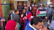 ناخبون يدعمون القضية الفلسطينية بأعلام فلسطين خلال الإدلاء بأصواتهم بلجان أسيوط