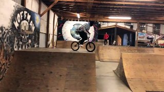 BMX rider jumps off top of half pipe at skatepark and faceplants