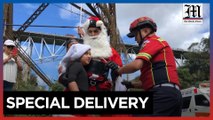 Santa firefighter rappels gifts down a bridge for Guatemalan kids