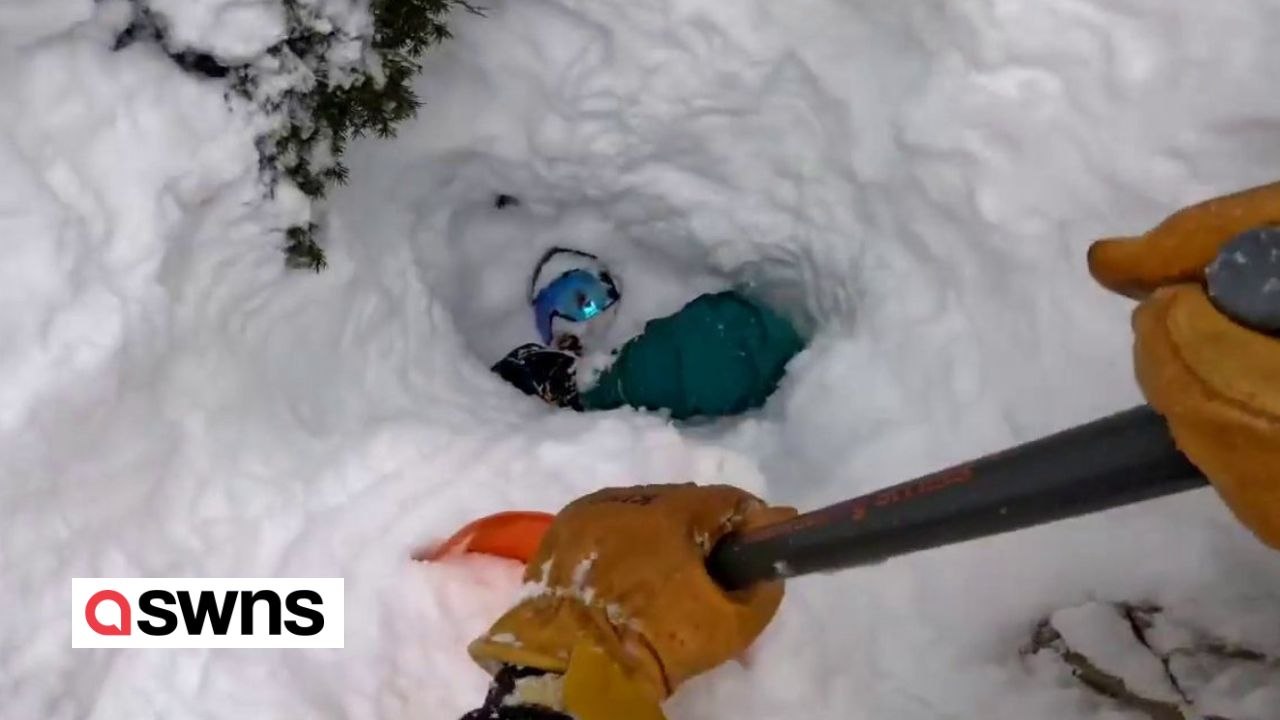 Skifahrer retten Snowboarder, der kopfüber im Schnee begraben ist