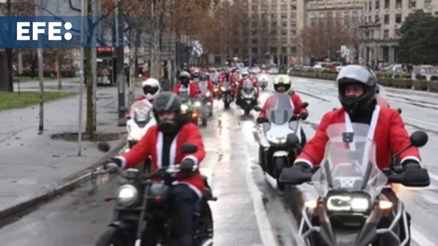 Moteros disfrazados de Papá Noel llevan regalos a niños en Belgrado