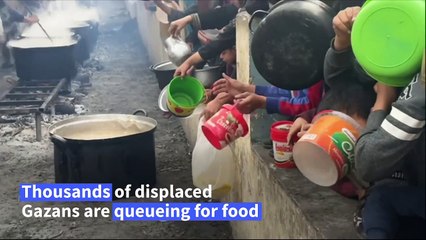 Palestinians wait with containers for food distribution in Rafah