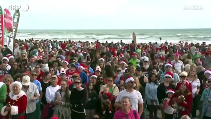 In Florida migliaia di "Babbo Natale" sul surf per raccogliere fondi