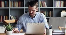 stock-footage-focused-business-man-entrepreneur-typing-on-laptop-doing-research-young-male-professional-using