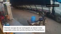 Homem escapa de ser esmagado ao deixar moto segundos antes de carreta tombar