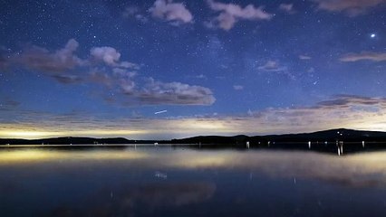 night sky with stars at a calm lake time lapse