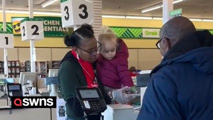 Supermarket worker helps mum by picking up crying toddler and scanning items with her