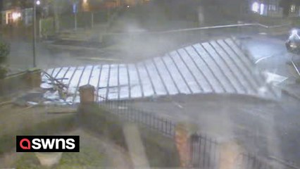 Driver narrowly escapes being hit by roof that flew off property