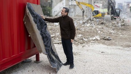 Enkazdan çıkardığı Atatürk rölyefini dükkanının önünde sergiliyor