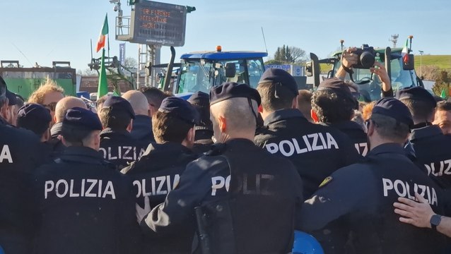 Il reparto mobile della polizia respinge gli agricoltori davanti al casello autostradale della A1