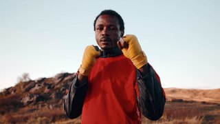 black-man-sports-uniform-stands-outdoors