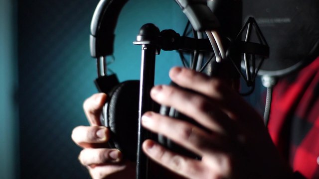 closeup-hands-of-singer-taking-off-headphones