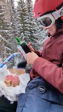 Skier Enjoys a Meal on Chairlift