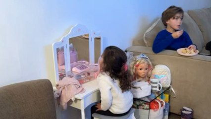 Mirror mischief: Little sister covertly glances at TV through the makeup table's mirror