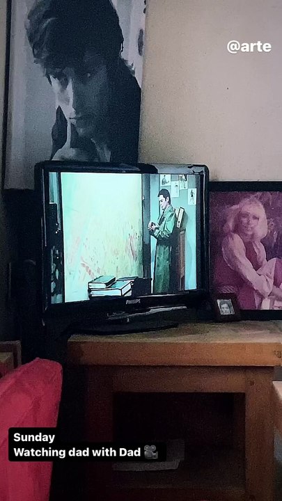 On découvre Alain Delon, barbu, regardant un de ses fims à la télévision au côté de son fils Alain-Fabien