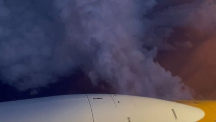 Friends reacting uniquely when their plane flies through a thunderstorm