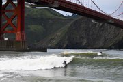 Yağmurlu havada Golden Gate Köprüsü altında sörf