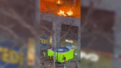 Bombero saltando a colchón de rescate tras quedar atrapado por las llamas