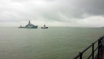 Royal Navy warship HMS Tyne sails into Portsmouth during rain showers
