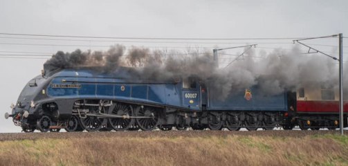 Sir Nigel Gresley steam locomotive racing through the English countryside