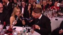 Roman Kemp and Kylie Minogue drink out of shoes together at Brit Awards 2024