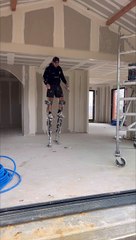 Worker on Stilts Shows How to Pick up Dropped Tool