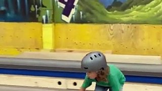 Boy on skateboard attempts 50-50 grind on rail at skatepark and lands on his arm