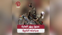 عجوز يبهر المارة بدراجته النارية