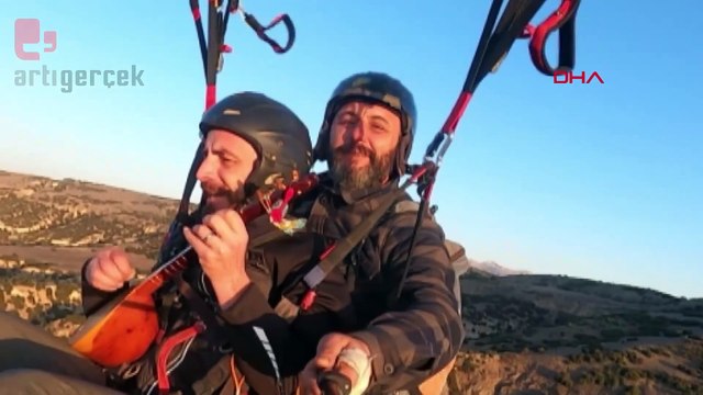 Yamaç paraşütüyle atladı, havada cura çalıp türkü söyledi