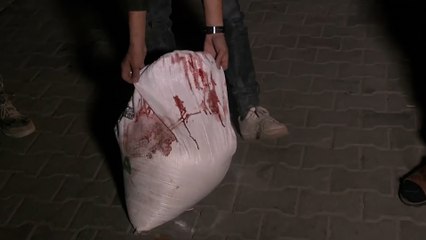 شاب يحمل كيس طحين مخضب بالدماء إلى مستشفى الشفاء