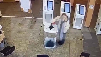 Una mujer vierte tinta verde en las urnas de un colegio electoral cerca de Moscú para anular los votos.