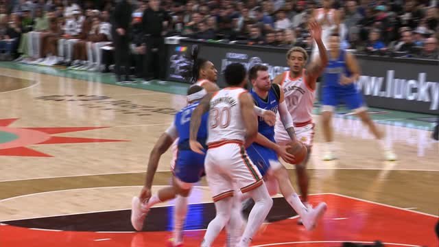 Doncic makes overhead assist while triple-teamed