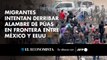 Migrantes intentan derribar alambre de púas en frontera entre México y EEUU