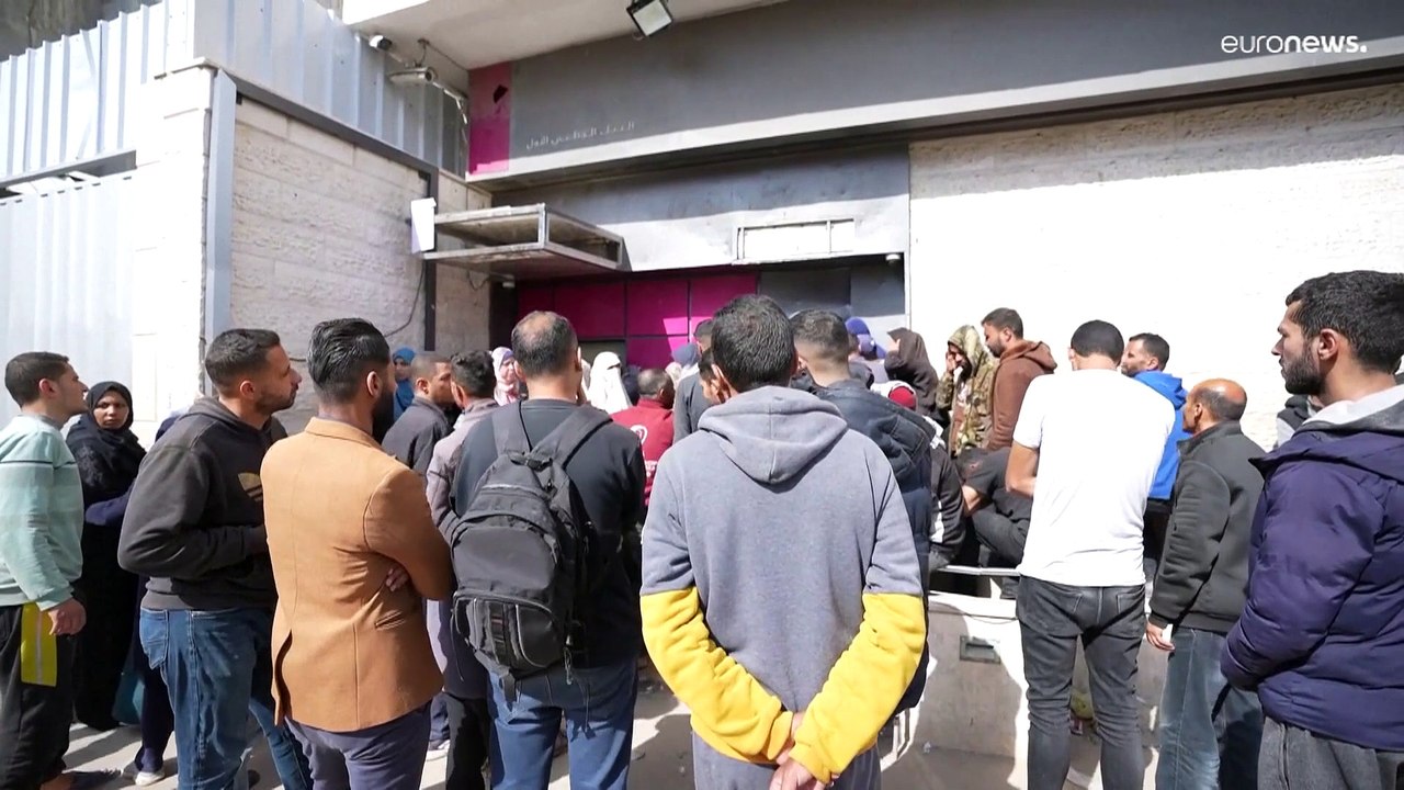 شاهد: لساعات أو أيام.. نازحون ينتظرون في طوابير أمام بنك فلسطين في دير البلح لسحب أموالهم