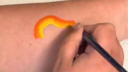 Forearm turns into a canvas as artist creates an eye-catching dinosaur design with face paints