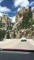 La gente que conduce ve a un hombre que atraviesa dos montañas en el Monte Rushmore