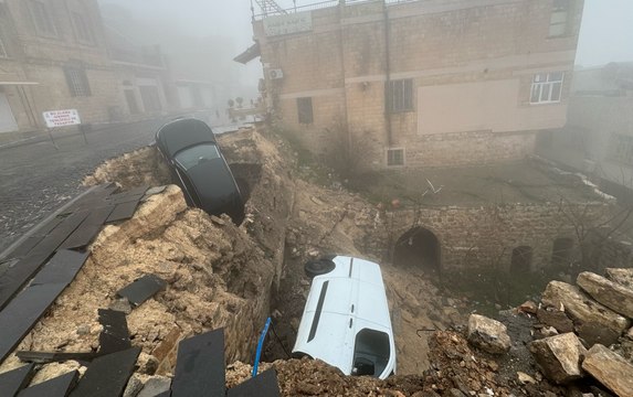 Sağanak nedeniyle çöken yoldaki 2 araç zarar gördü