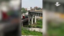 Tráiler queda a punto de caer desde puente tras volcadura en autopista México
