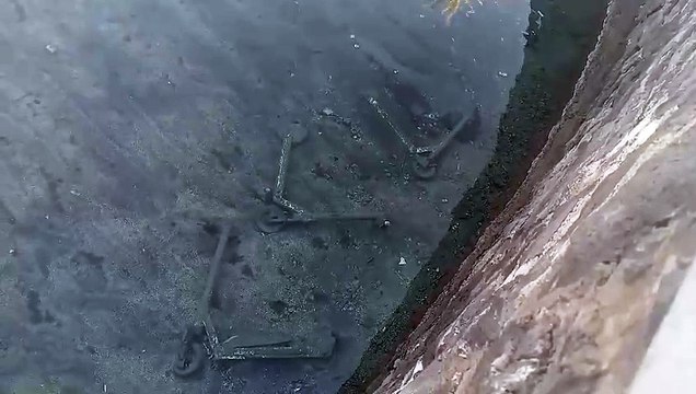 Tres patinetes de Link abandonados en el agua que rodea el Castillo Negro, en Santa Cruz de Tenerife