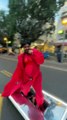 Persona vestida como Rihanna y montada en un monopatín eléctrico por las calles.