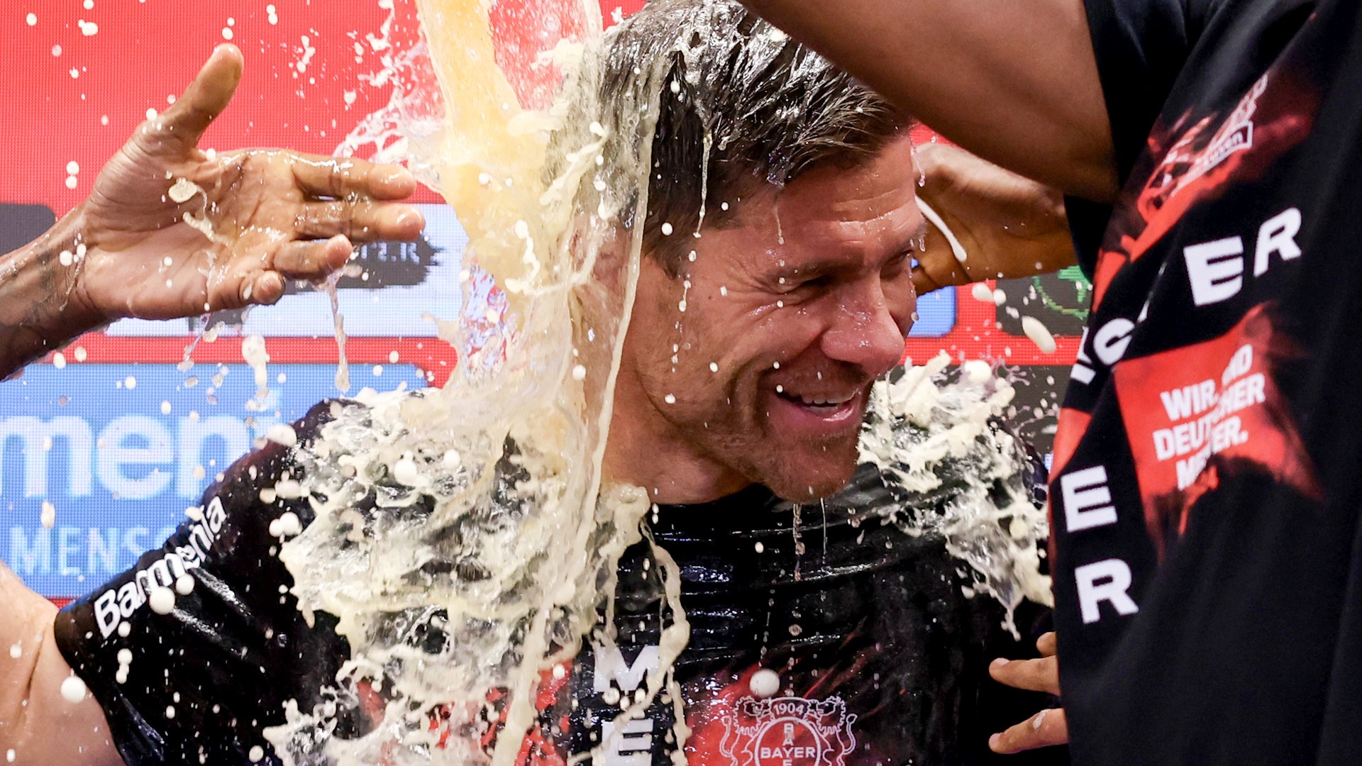 Xabi Alonso duchado en cerveza por los jugadores del Leverkusen tras ganar su primera Bundesliga