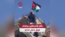 علم فلسطين يرفرف فوق منزل مدمر