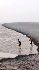 Des pêcheurs courent contre la marée