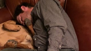 Woman captures hilariously endearing moment of her husband and dog napping on the couch