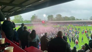 Crawley Town fans invade the pitch after the Reds secure a play-off place