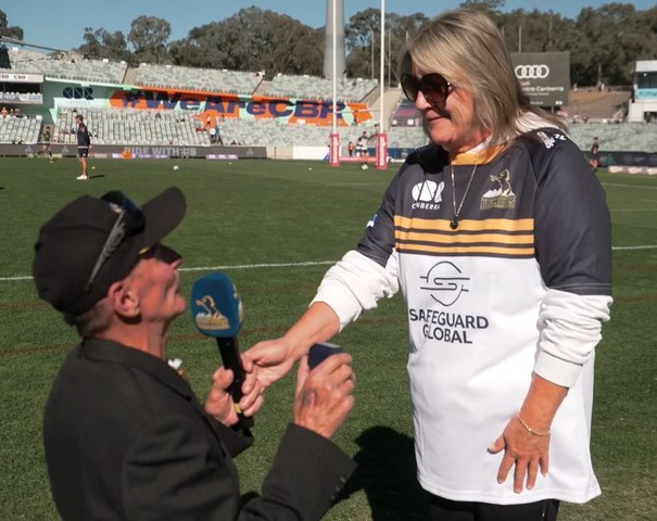 Hurricanes fan Richard Hare proposes to partner Penny before the Brumbies game at Canberra Stadium.