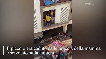 Bambino di otto mesi sta per cadere dal tetto, salvo ggrazie a un uomo che lo prende per una gamba