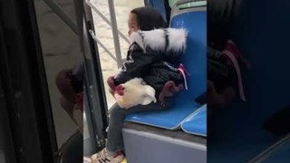 Little Girl Travels by Bus With Her Pet Chicken